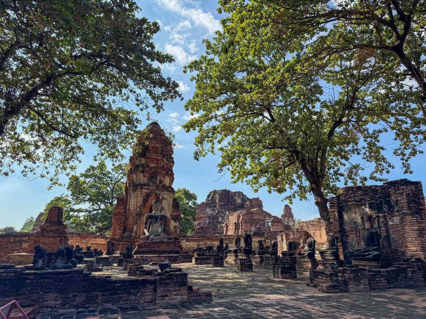 Sakrale, historische thailändische Sehenswürdigkeit, deren Wände von mehreren Buddha-Statuen gesäumt sind.